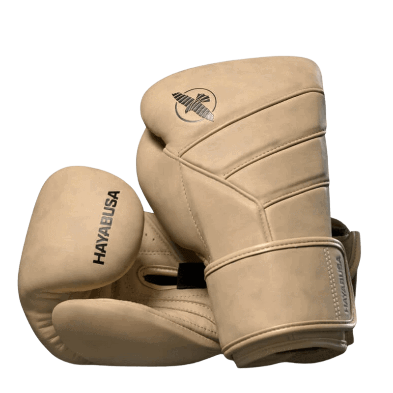 De linker Hayabusa T3 LX bokshandschoen in tan, liggend op de rechter met focus op het valklogo en de gestikte details van de constructie.