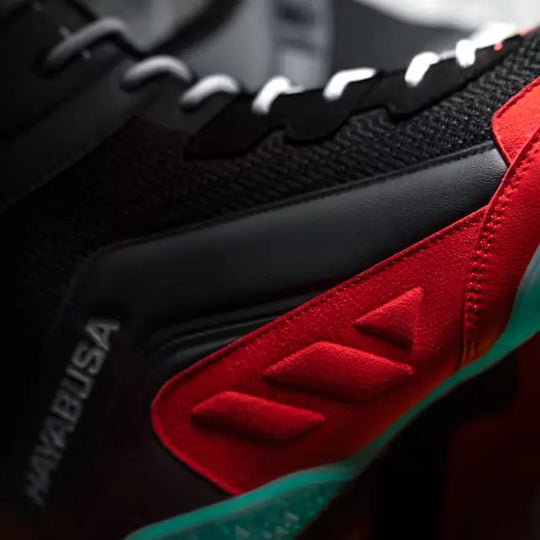 Close-up van Hayabusa Talon schoenen, met focus op het rode en zwarte design en merknaam.