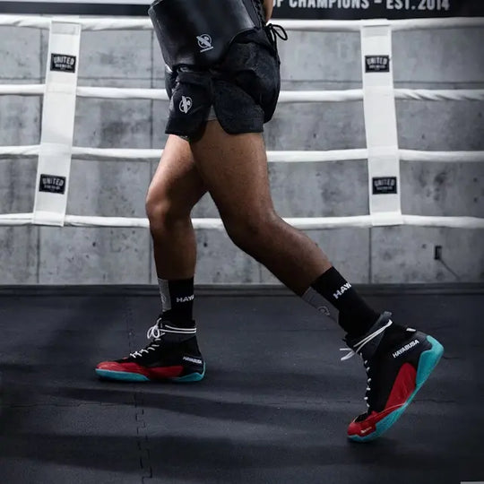 MMA-vechter draagt Hayabusa Talon schoenen tijdens training in de ring, met focus op de schoenen en beweging.