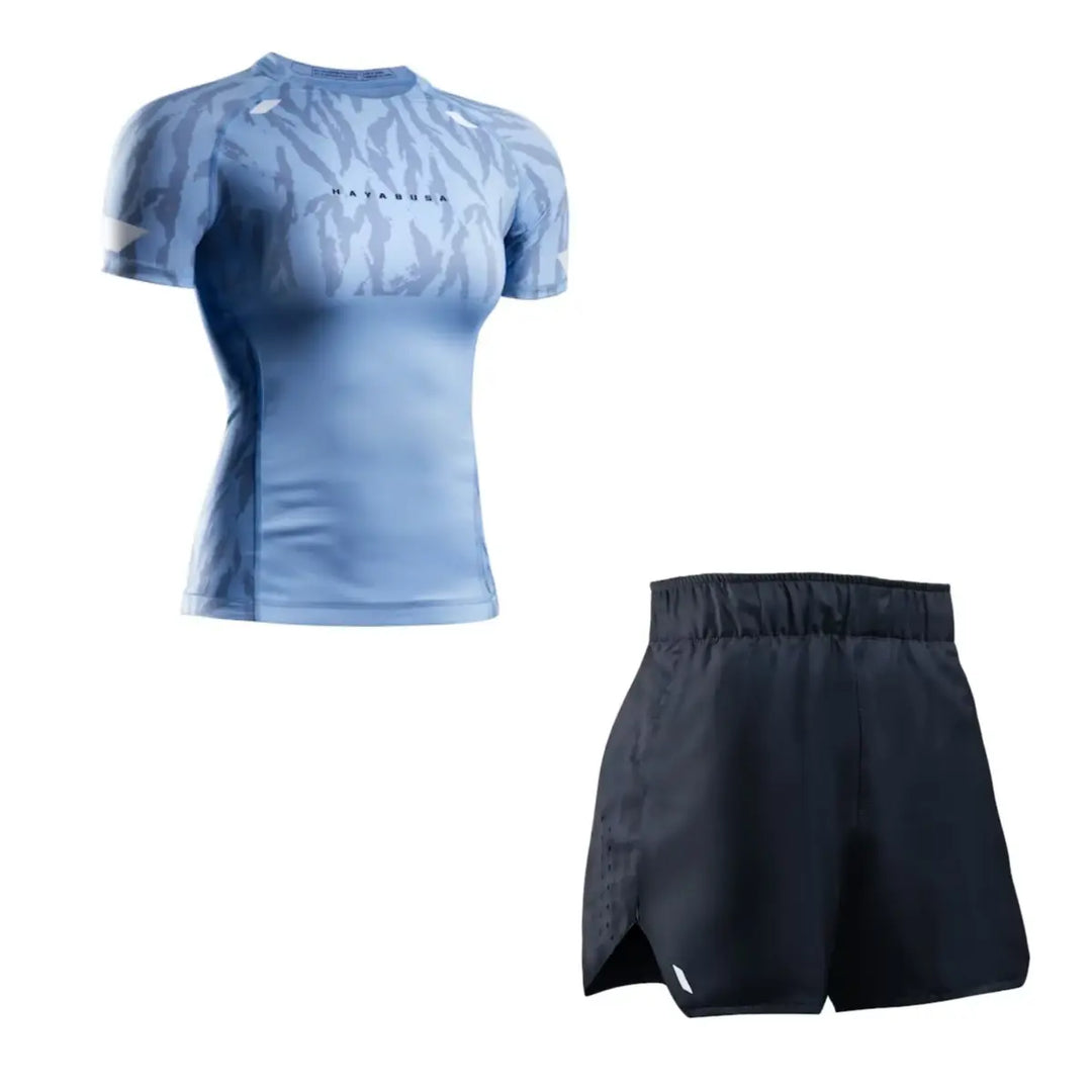 Productfoto van een Hayabusa dames set bestaande uit een lichtblauwe short sleeve rashguard met subtiel patroon en een zwarte trainingsshort, weergegeven tegen een witte achtergrond.