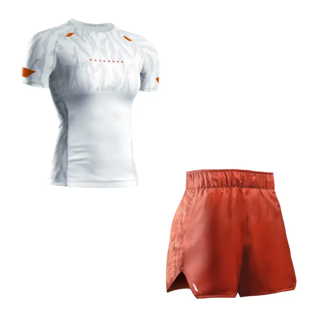 Productfoto van een Hayabusa heren set met een witte short sleeve rashguard met subtiele camouflage-accenten en oranje details, gecombineerd met een bijpassende oranje trainingsshort, afgebeeld tegen een witte achtergrond.
