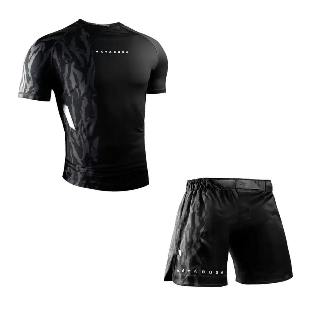 Productfoto van een Hayabusa heren set met een zwarte camouflage short sleeve rashguard en een bijpassende zwarte trainingsshort, afgebeeld tegen een witte achtergrond.