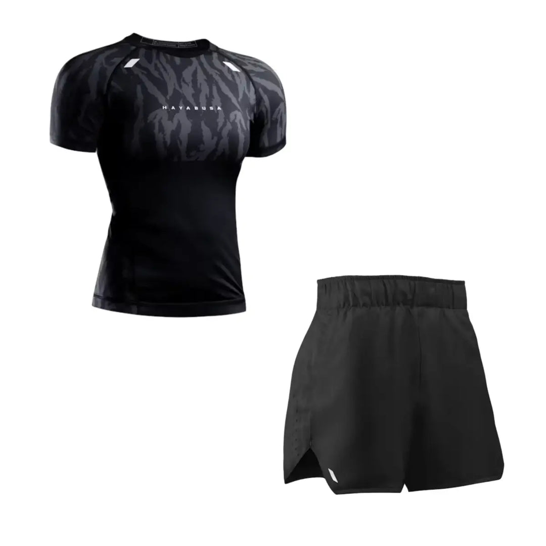 Productfoto van een Hayabusa heren set bestaande uit een zwarte short sleeve rashguard met subtiel camouflagepatroon op de schouders en een bijpassende zwarte trainingsshort. De set is strak en functioneel ontworpen en wordt vrijstaand weergegeven tegen een witte achtergrond.