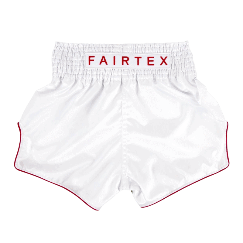 Wit Fairtex Muay Thai-short met rood afgebiesde rand en het merklogo op de elastische tailleband.