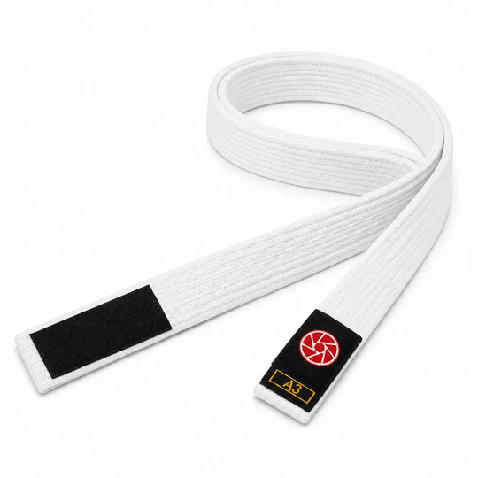 Witte BJJ band in maat A3 met zwarte uiteinden en een rood-wit logo op het label. De stevige geweven structuur maakt de band geschikt voor BJJ-trainingen, graduaties en dagelijks gebruik op de mat.