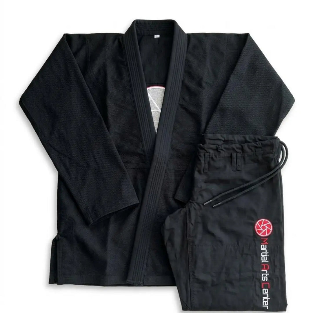 Zwarte BJJ gi set bestaande uit jas en broek samen gepresenteerd in nette flat lay op witte achtergrond