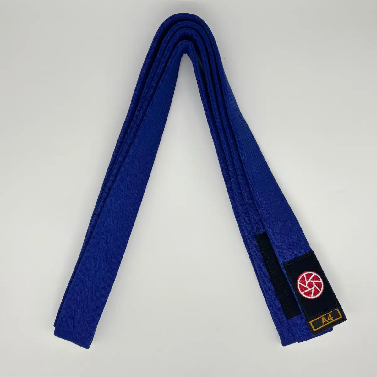 Blauwe Martial Arts Center BJJ-band maat A4, netjes opgevouwen, met zwart label en rood-wit logo op een witte achtergrond.
