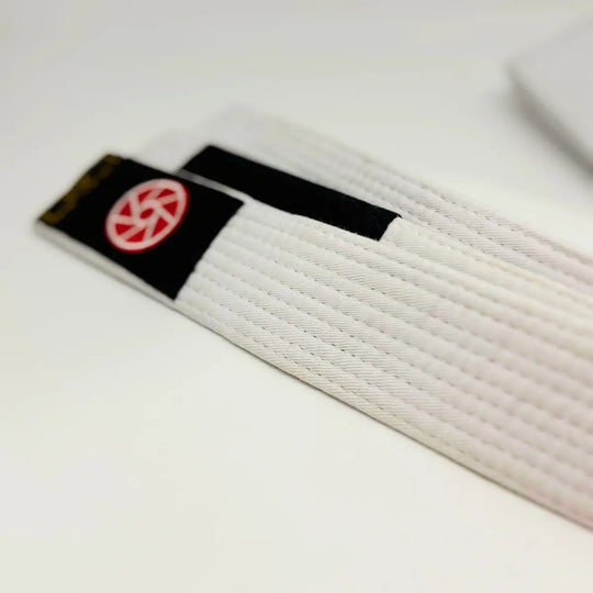 Witte Martial Arts Center BJJ band met zwart vlak en rood logo op lichte achtergrond.