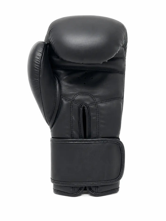 Zwarte bokshandschoen gefotografeerd vanaf de achterkant met brede klittenbandsluiting, duimbescherming en ventilatiegaatjes bij de handpalm. De stevige padding en ondersteunende polsband maken de handschoen geschikt voor boksen, kickboksen en intensieve stoottrainingen.