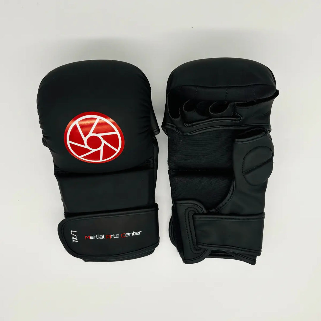 Bovenaanzicht van een paar zwarte Martial Arts Center MMA-handschoenen met rood rond logo en openvingerdesign op witte achtergrond.