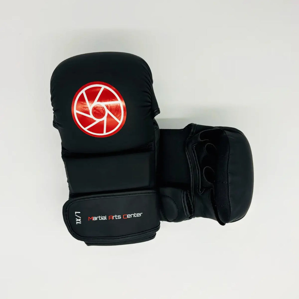 Bovenaanzicht van zwarte Martial Arts Center MMA-handschoen met rood rond logo en openvingerdesign op witte achtergrond.