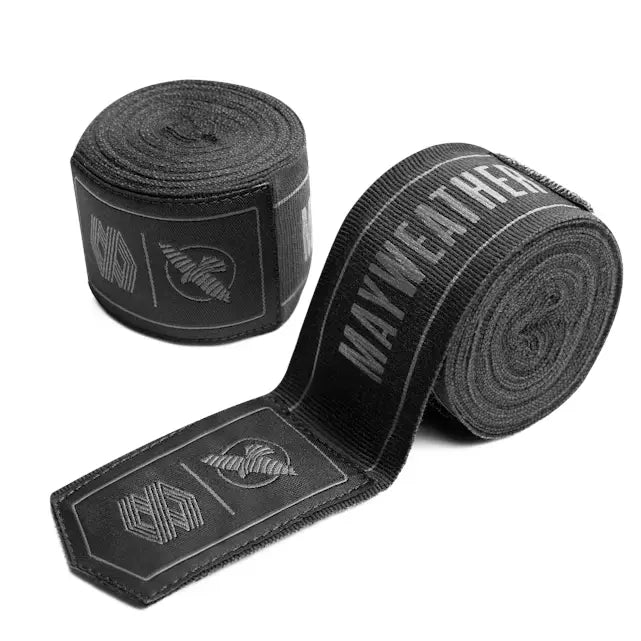 Zwarte Hayabusa Mayweather handwraps opgerold, met grijze branding en klittenbandsluiting, geschikt voor boksen en vechtsporttraining