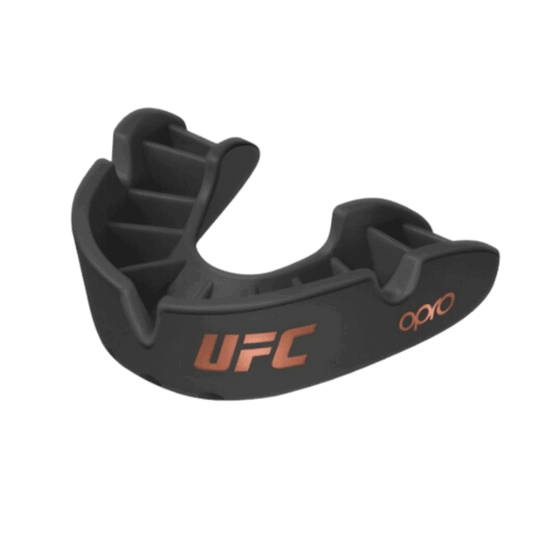 Een zwarte Opro UFC mondbeschermer met oranje accenten, anatomische vinnen voor een persoonlijke pasvorm en ademhalingskanalen.