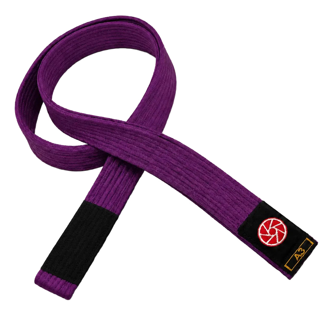 Paarse BJJ band in maat A3 met zwart uiteinde en een rood-wit logo op het label. De stevige geweven structuur maakt de band geschikt voor BJJ-trainingen, graduaties en dagelijks gebruik op de mat.