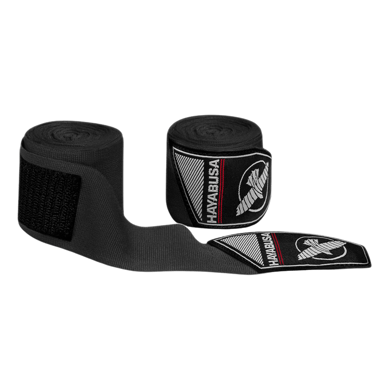 Een uitgerolde rood-zwarte bandage met een zwart klittenband uiteinde en een zwart etiket met het witte Hayabusa logo, liggend naast de zwarte bandagehouder.