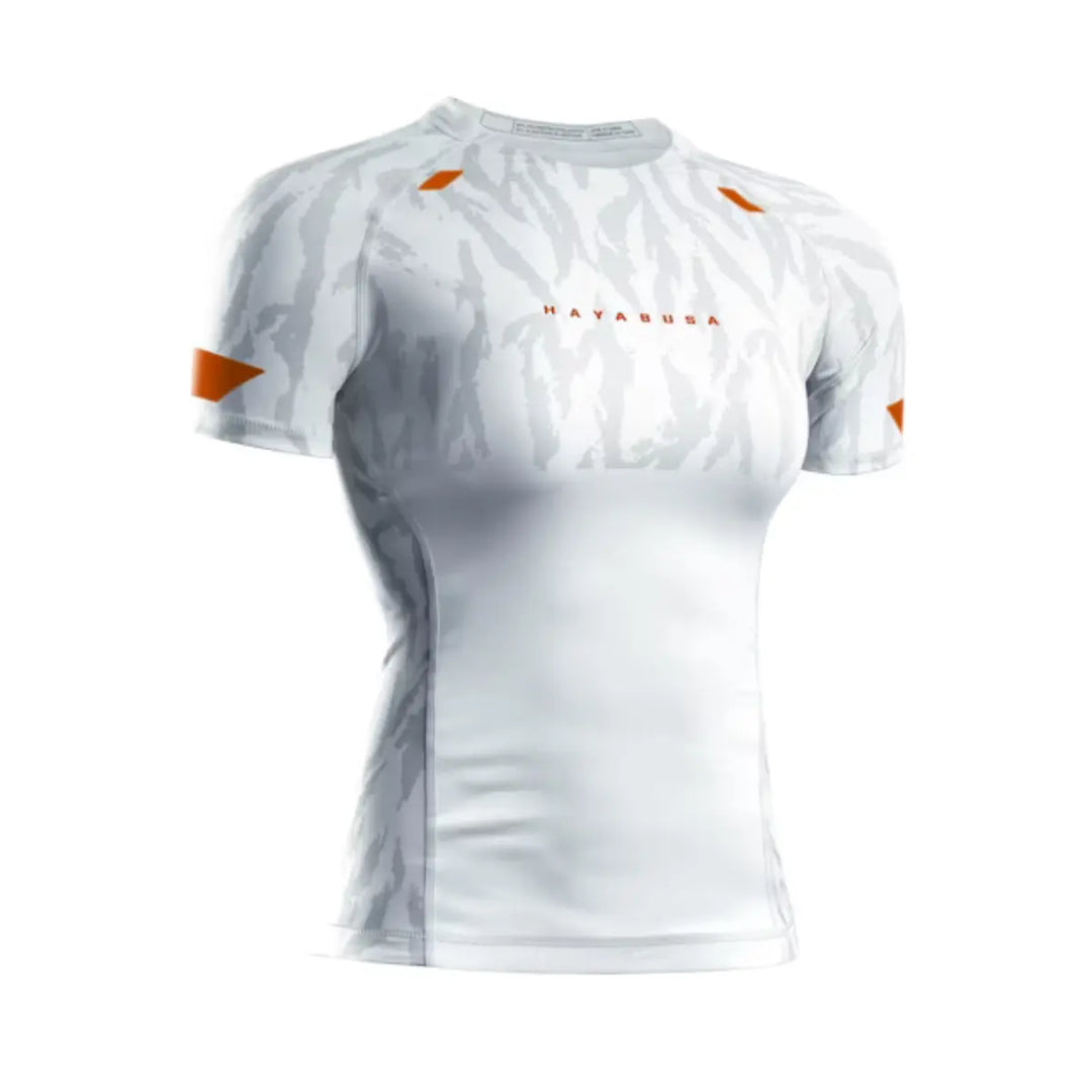 Vooraanzicht van de Hayabusa Apex dames rashguard korte mouw in Ash White, met lichtgrijs camo-design en oranje logo-accenten.