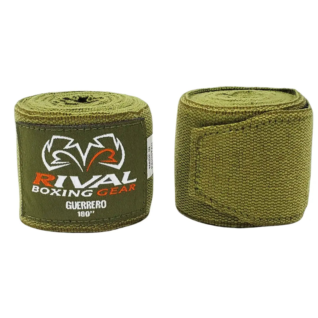 Twee opgerolde Rival Bandage Guerrero Khaki Groen handwraps met wit-oranje Rival-logo. De 180-inch elastische bandages bieden uitstekende ondersteuning voor polsen en knokkels, ideaal voor intensieve bokstrainingen en sparringssessies met maximale stabiliteit.
