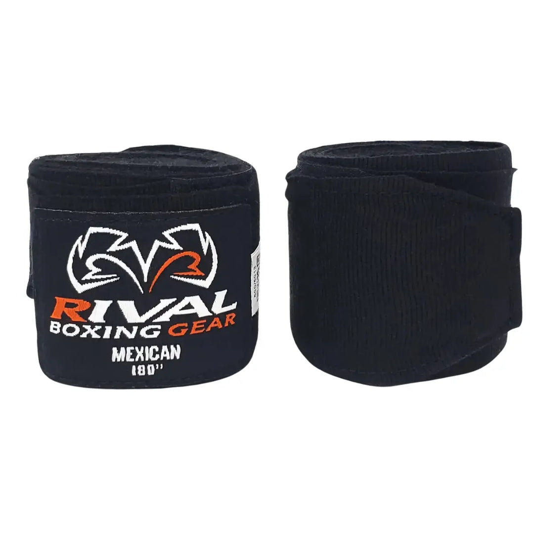 Twee strak opgerolde Rival Bandage Mexican Zwart handwraps met wit-oranje Rival-logo. De elastische bandages van 180 inch zorgen voor optimale pols- en knokkelondersteuning tijdens bokstraining, ideaal voor zowel beginners als ervaren boksers.