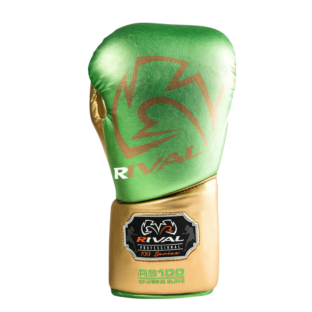 De Rival Bokshandschoen RS100 Professional Groen Goud is afgebeeld op een witte achtergrond en toont een opvallende metallic groene bovenkant met gouden manchet. Het grote Rival-logo en het RS100-embleem onderstrepen de professionele kwaliteit van de handschoen. Deze foto benadrukt het luxueuze design, de perfecte afwerking en de kracht van deze exclusieve bokshandschoen.