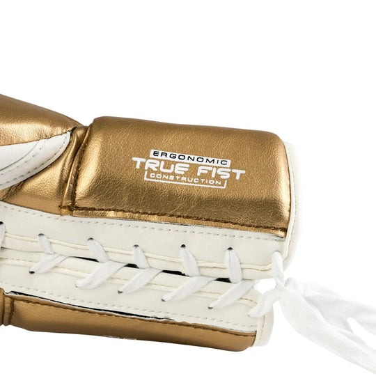 Close-up van de Rival Bokshandschoen RS100 Detail Wit Goud, waarin de veterzijde en het opschrift “Ergonomic True Fist Construction” duidelijk zichtbaar zijn. De combinatie van wit en metallic goud straalt elegantie en klasse uit, terwijl de witte veters en strakke stiksels de precieze afwerking benadrukken. Deze afbeelding toont perfect de ergonomische pasvorm en premium kwaliteit van de handschoen.
