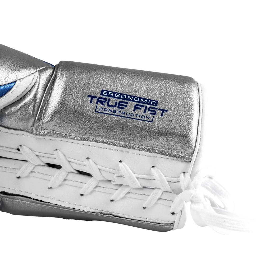 De Rival Bokshandschoen RS100 Detail Zilver toont een close-up van de veterzijde van de handschoen. De zilverkleurige afwerking benadrukt het opschrift “Ergonomic True Fist Construction”, dat verwijst naar het ergonomische ontwerp van de handschoen. De witte veter en nette stiksels laten het vakmanschap en de hoogwaardige constructie van de Rival RS100 duidelijk zien.