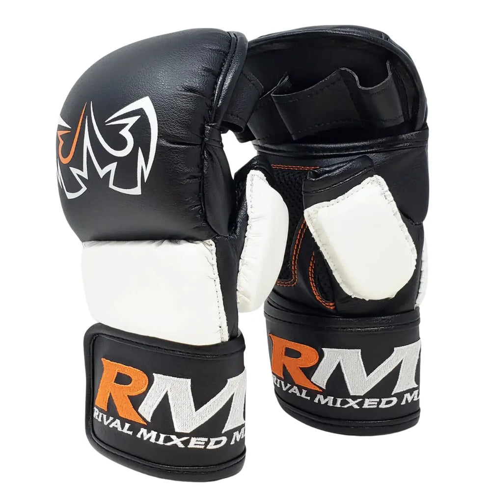 De Rival MMA Handschoenen Zwart Wit van achteren gezien, met zichtbaar oranje stikwerk en het RIVAL MIXED MARTIAL ARTS-logo op de polsband. De openvingerstructuur biedt optimale grip en ventilatie, terwijl de padding en verstelbare sluiting zorgen voor veiligheid en ondersteuning tijdens training of sparring.