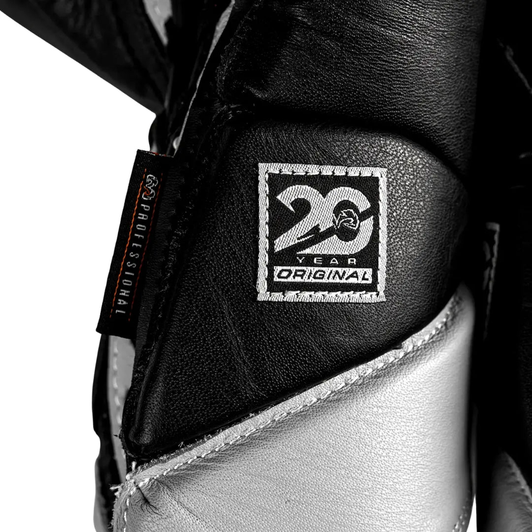 Close-up van de Rival RS1 Bokshandschoenen met het “20 Year Original” jubileumlabel en “Professional” tag. De zwart-zilveren afwerking benadrukt het vakmanschap en de premium kwaliteit van deze limited edition bokshandschoenen, ontworpen voor professionele boksers die waarde hechten aan authenticiteit en traditie.