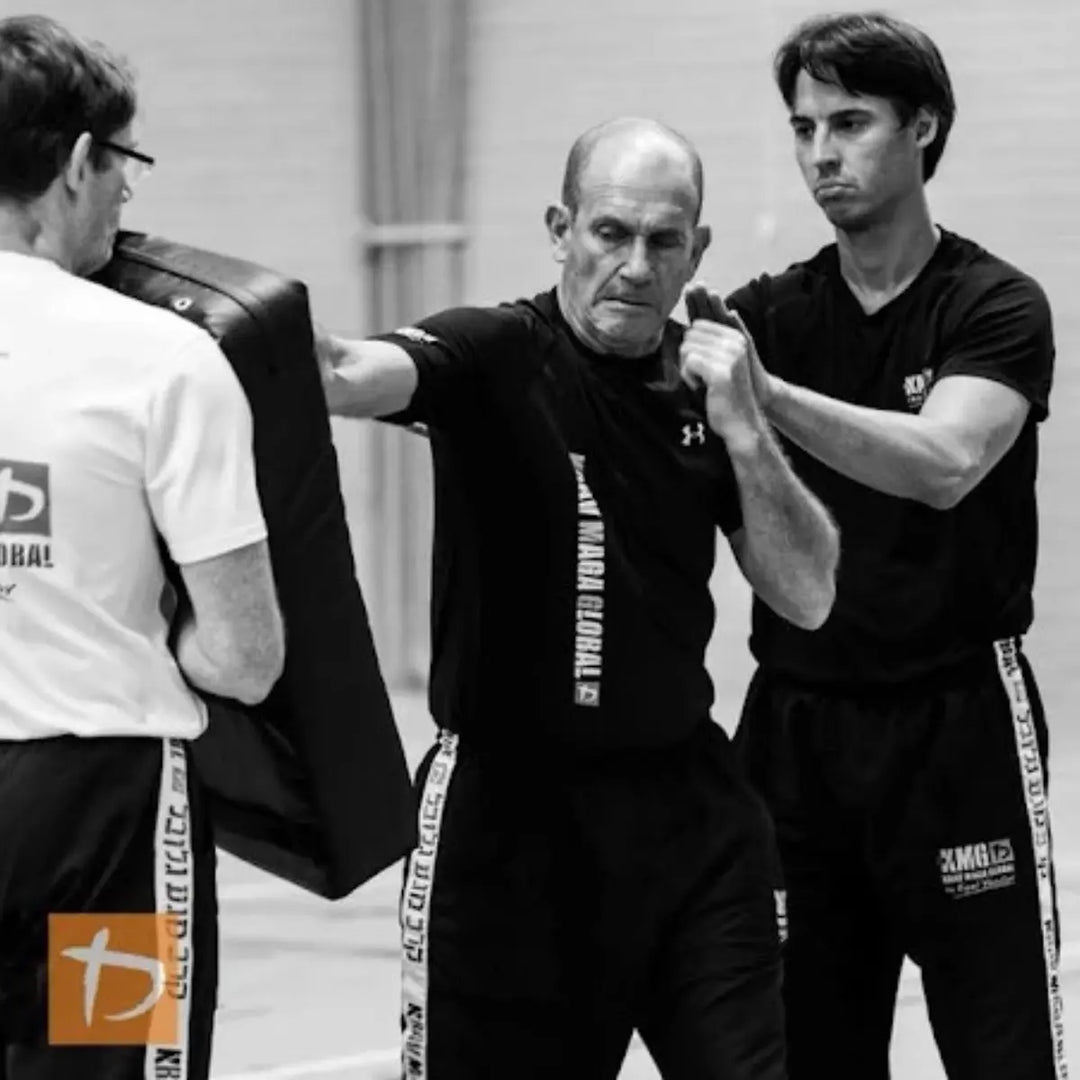 Man oefent stoottechniek op een stootkussen tijdens training