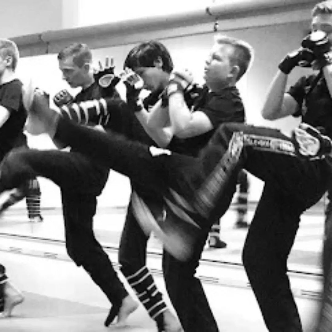 Groepje sporters oefent gezamenlijk een traptechniek tijdens training