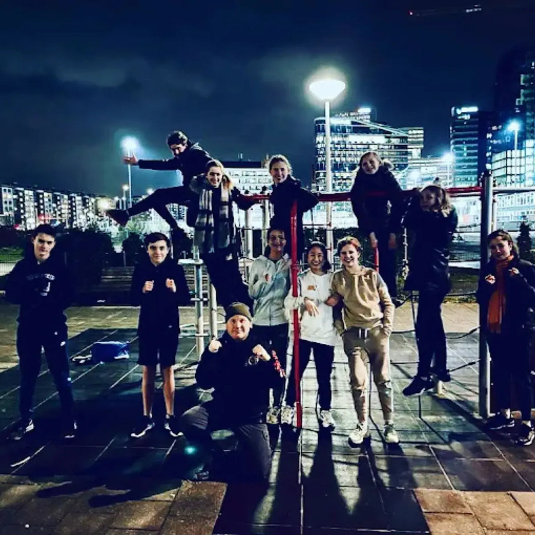 Groep mensen poseert samen in een klimrek tijdens buitentraining