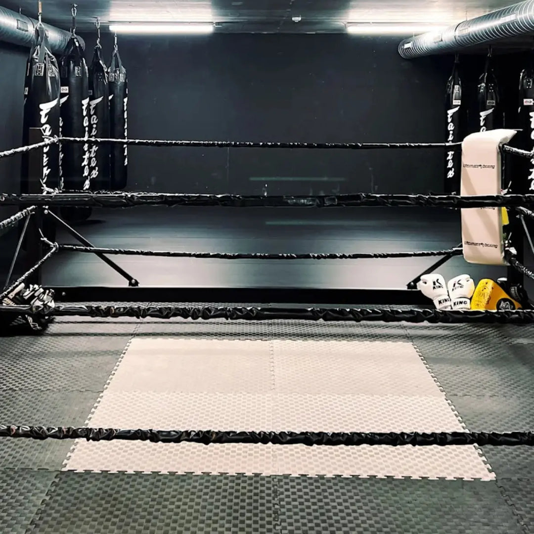 Boksring omringd door meerdere bokszakken in de sportschool