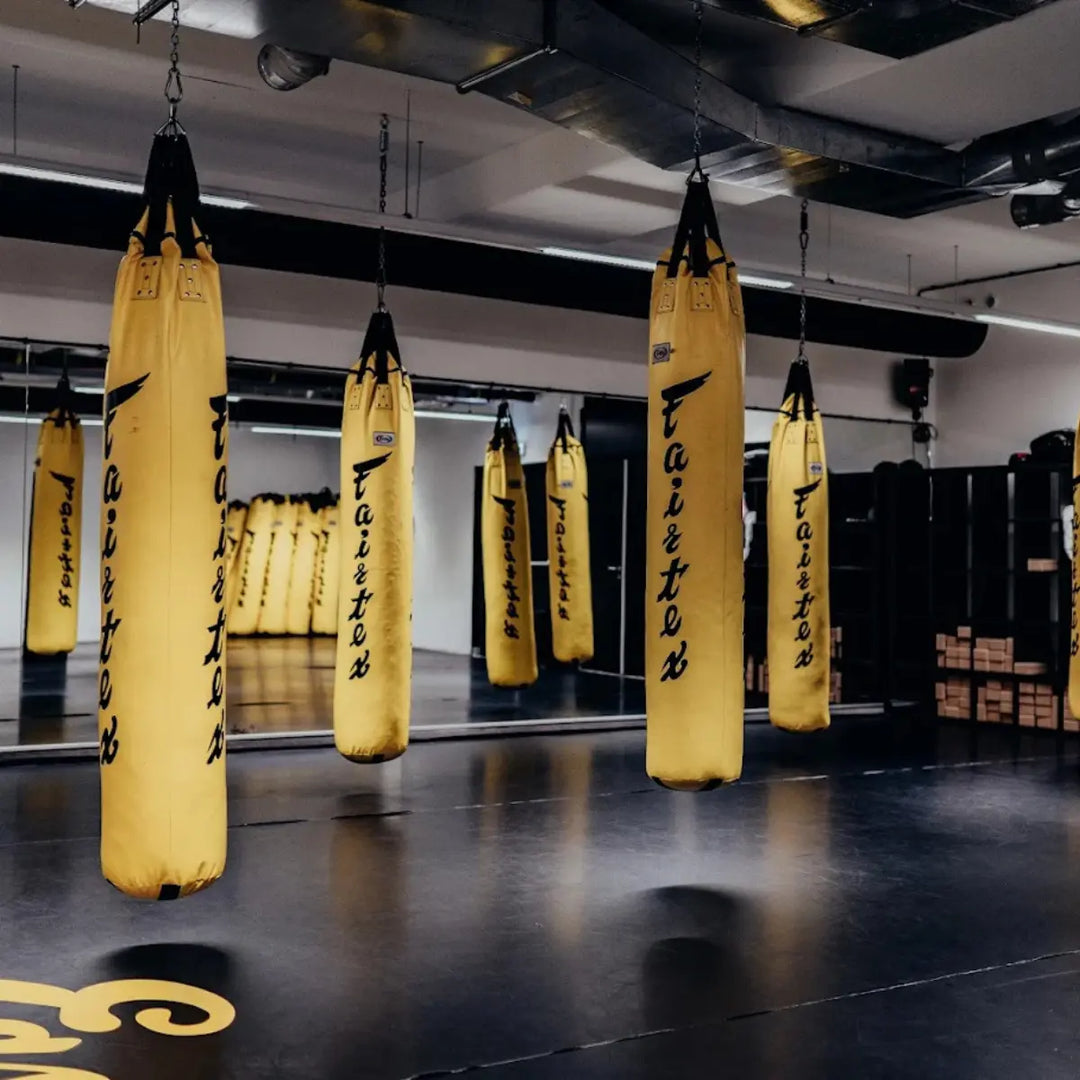 Meerdere bokszakken hangen klaar voor training in de sportschool
