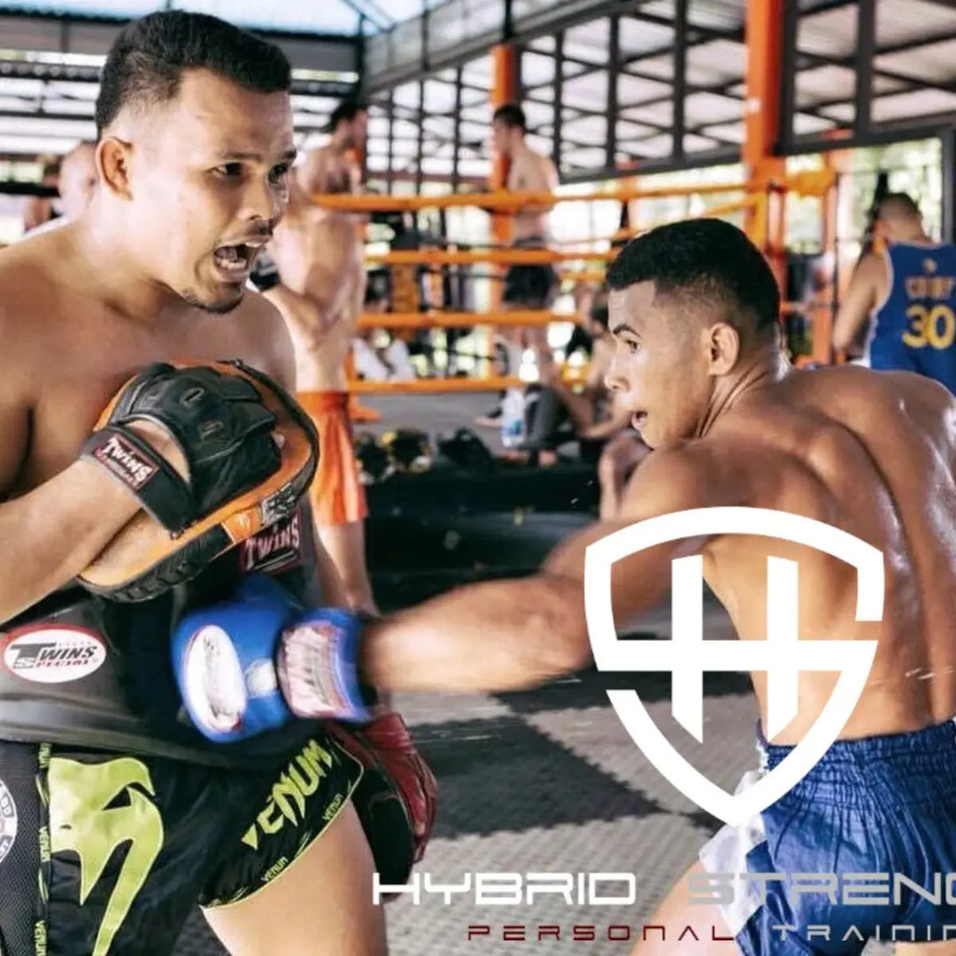 Muay Thai-trainer vangt stoot op met pads tijdens training