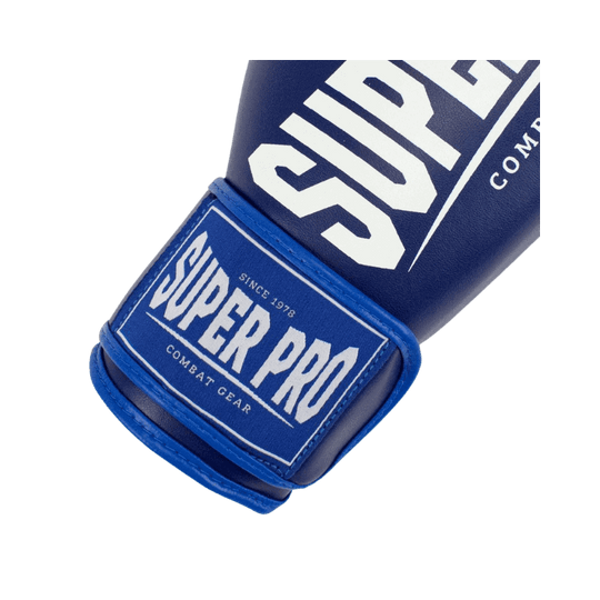 Close-up van het label van een Super Pro bokshandschoen, waarop het merk "Super Pro Combat Gear" te zien is. De klittenbandsluiting is zichtbaar, wat zorgt voor een goede pasvorm om de pols.