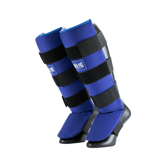 Een paar blauwe Super Pro scheenbeschermers met zwarte klittenbandsluitingen, ontworpen voor gebruik bij kickboksen en andere vechtsporten. Ze bieden zowel scheen- als voetbescherming.