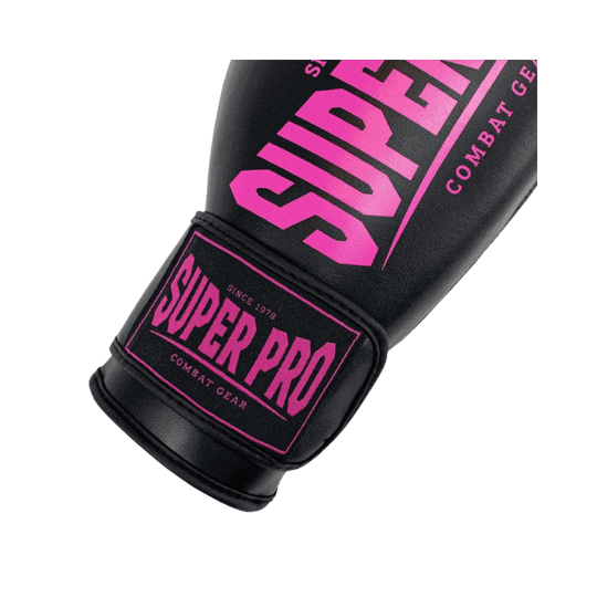 Close-up van het roze Super Pro logo op de polsband van een zwarte bokshandschoen. Het logo is duidelijk zichtbaar op de klittenbandsluiting.