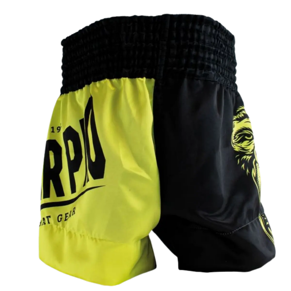 Achteraanzicht van het Super Pro kickboksbroekje in neon geel met zwarte panelen. De brede zwarte elastische tailleband zorgt voor een stevige en comfortabele pasvorm tijdens elke trainingssessie. De contrasterende kleurvlakken geven het broekje een dynamische en sportieve uitstraling. Het lichte en soepele materiaal biedt optimale bewegingsvrijheid bij trappen, draaien en snelle combinaties in de gym.