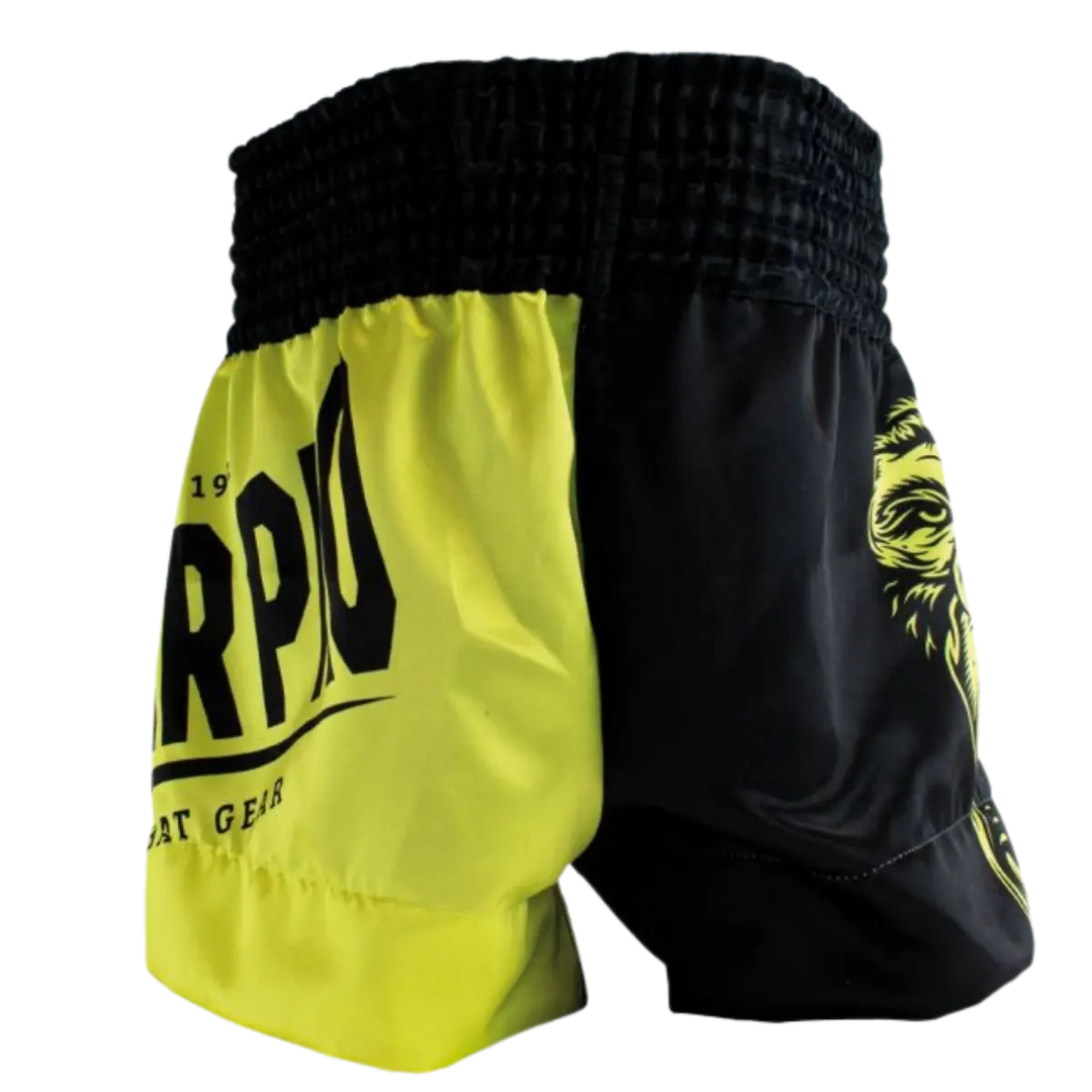 Achteraanzicht van het Super Pro kickboksbroekje in neon geel met zwarte panelen. De brede zwarte elastische tailleband zorgt voor een stevige en comfortabele pasvorm tijdens elke trainingssessie. De contrasterende kleurvlakken geven het broekje een dynamische en sportieve uitstraling. Het lichte en soepele materiaal biedt optimale bewegingsvrijheid bij trappen, draaien en snelle combinaties in de gym.