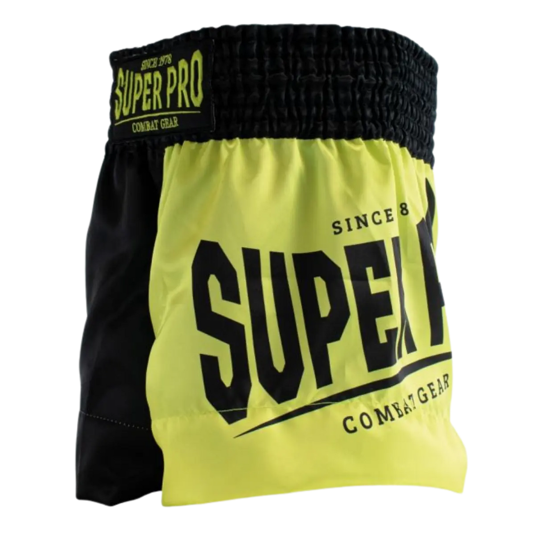 Vooraanzicht van het Super Pro kickboksbroekje in een opvallende neon gele kleur met contrasterende zwarte zijkanten. Het grote “SUPER PRO” logo aan de voorkant geeft het broekje een krachtige en herkenbare uitstraling. De brede, elastische tailleband met merklabel zorgt voor een stevige en comfortabele pasvorm tijdens elke training. Het lichte materiaal en de ruime snit bieden optimale bewegingsvrijheid bij trappen, knieën en snelle combinaties in de gym.