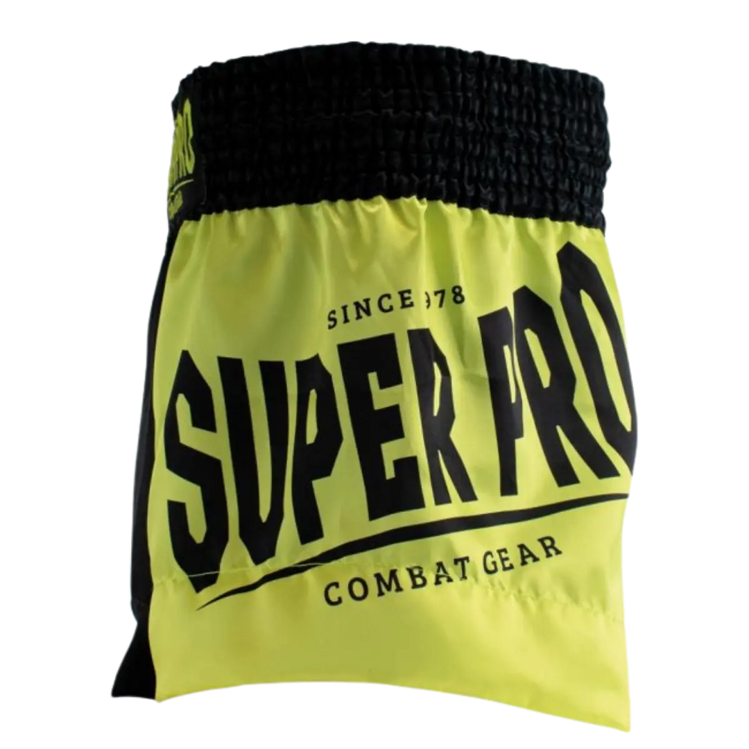Zijaanzicht van het Super Pro kickboksbroekje in een opvallende neon gele kleur met zwarte accenten. Het grote “SUPER PRO” logo en de tekst “Combat Gear” geven het broekje een krachtige, sportieve uitstraling. De brede zwarte elastische tailleband zorgt voor een stevige en comfortabele pasvorm tijdens intensieve trainingen. Dankzij het lichte en soepele materiaal biedt dit broekje maximale bewegingsvrijheid bij trappen, knieën en snelle combinaties in de gym.