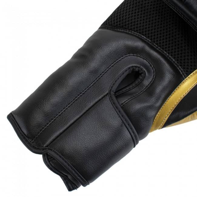 Close-up van de Super Pro kickbokshandschoen Ace in zwart met goudaccent. De leren afwerking en geventileerde mesh-zone zorgen voor comfort en ademend vermogen. Ontworpen voor een stevige grip en natuurlijke vuistpositie tijdens intensieve trainingen.