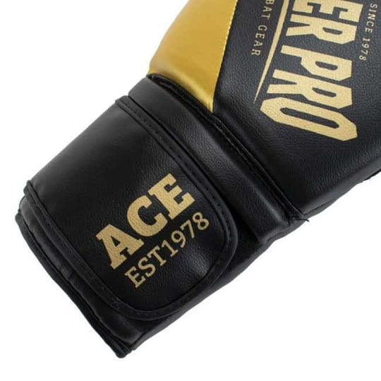 Detailopname van de Super Pro Bokshandschoenen ACE Goud, met zwarte polsband waarop “ACE EST1978” in goud is gedrukt, ontworpen voor kracht, duurzaamheid en premium uitstraling.