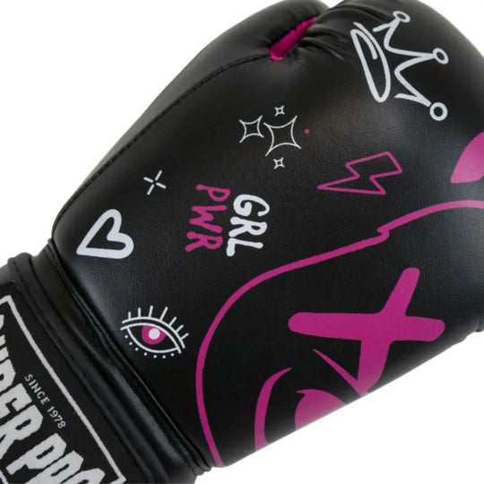 Deze close-up toont het design van de Super Pro Kids Bear bokshandschoen met kleurrijke symbolen zoals een kroon, hartje, bliksem en de tekst “GRL PWR”. Het grote roze berenmotief loopt over de voorzijde van de handschoen. De zwarte kunstlederen afwerking en het Super Pro-logo op de sluiting benadrukken de stevige, sportieve kwaliteit.