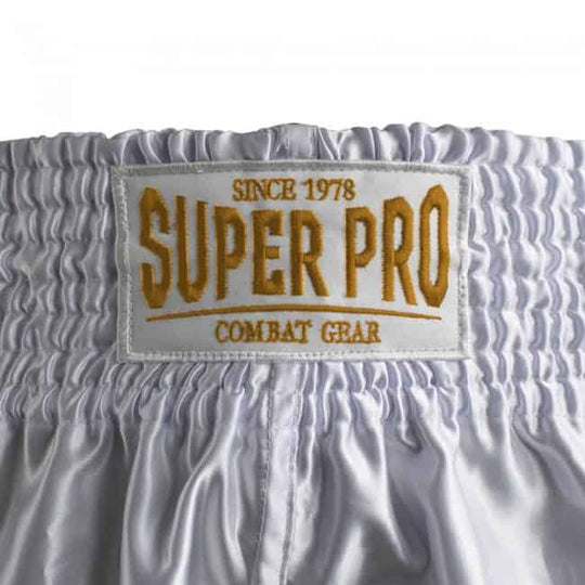 Close-up van de achterkant van het Super Pro Brave kickboksbroekje met een geborduurd label in goudkleurige letters. De elastische tailleband zorgt voor een stevige pasvorm tijdens het trainen of sparren. Het label toont het merklogo en de tekst "Since 1978 – Combat Gear".