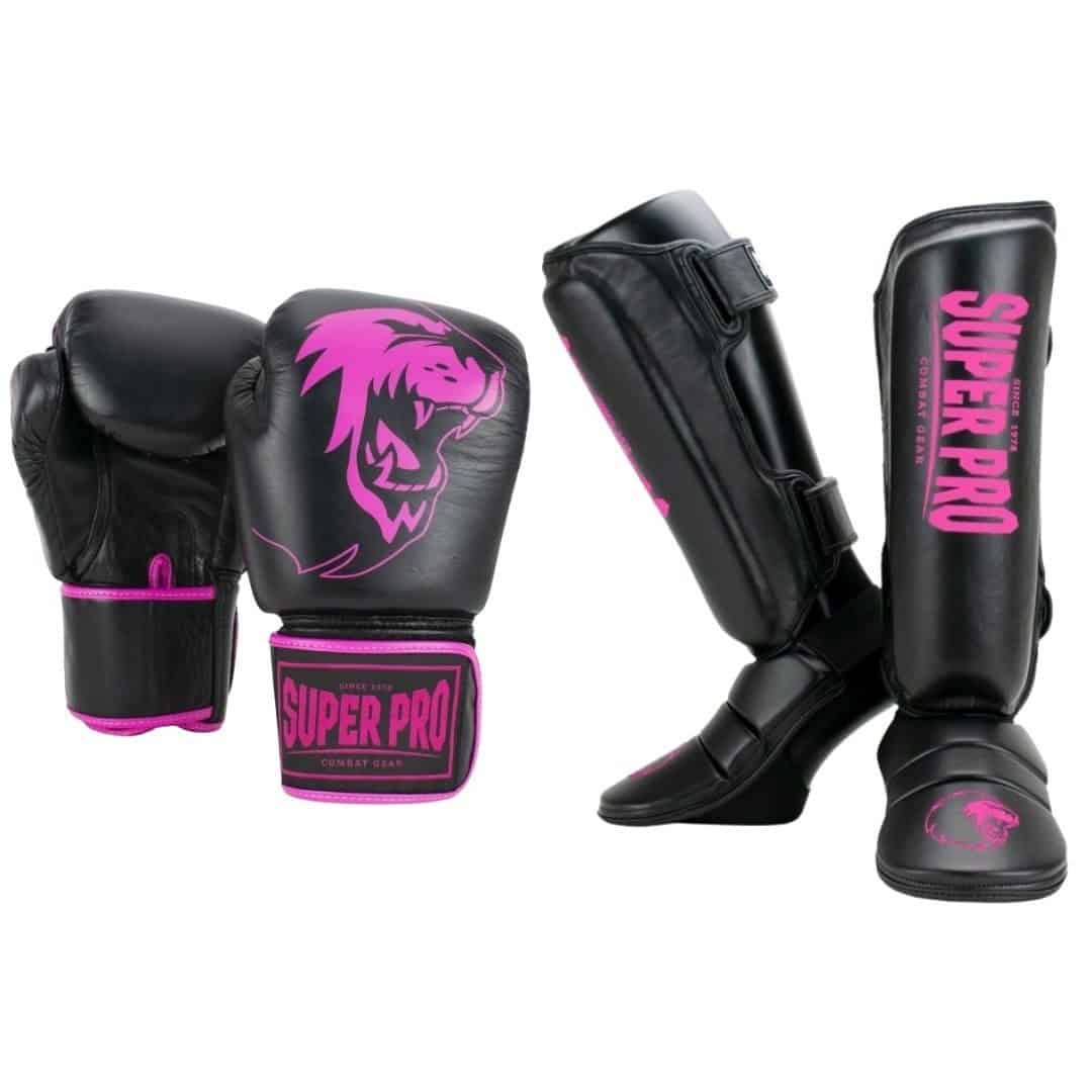 Een zwarte kickboksset bestaande uit twee handschoenen en twee scheenbeschermers, allen met roze Super Pro logo's.