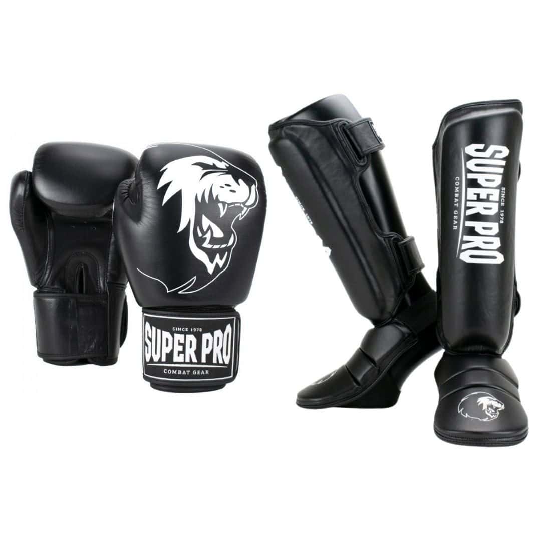 Een complete zwarte kickboksset, bestaande uit bokshandschoenen en scheenbeschermers, met witte Super Pro logo's.