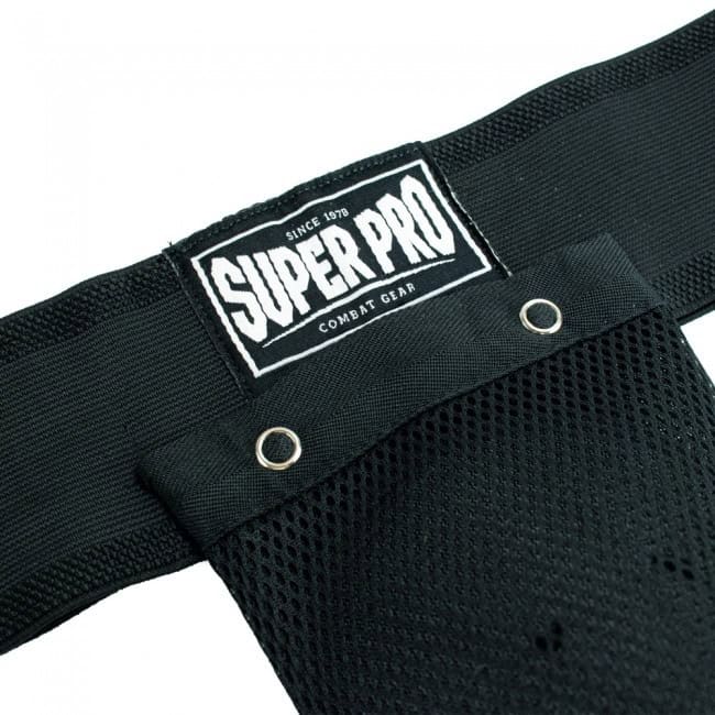 Close-up van het witte Super Pro Combat Gear logo op de zwarte tailleband van een kruisbeschermer, met de metalen oogjes van het mesh-gedeelte.