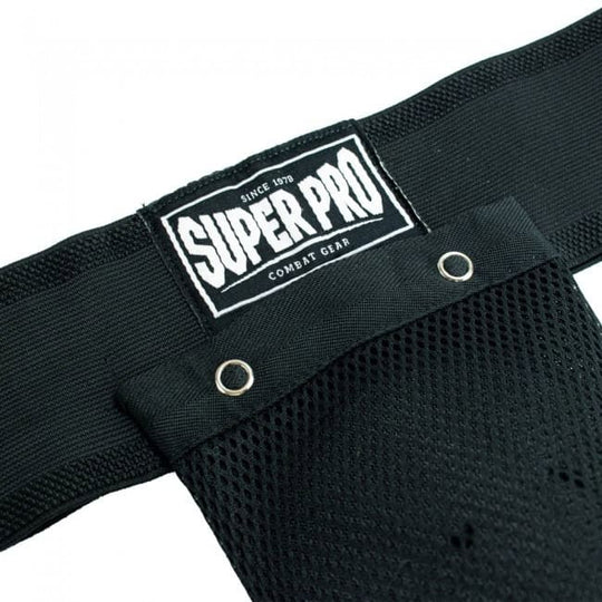 Close-up van het witte Super Pro Combat Gear logo op de zwarte tailleband van een kruisbeschermer, met de metalen oogjes van het mesh-gedeelte.