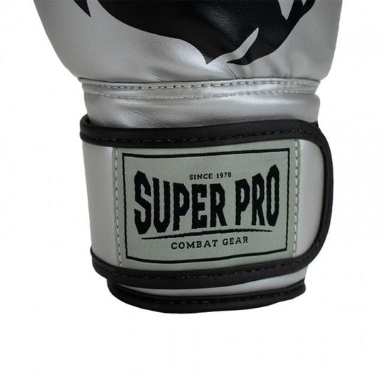 Detailafbeelding van de stevige klittenbandsluiting van de zilveren Super Pro Talent bokshandschoen voor kinderen. De sluiting toont het ‘Super Pro Combat Gear’ logo en zorgt voor extra polsondersteuning. De afwerking met zwart stiksel benadrukt de kwaliteit en duurzaamheid.