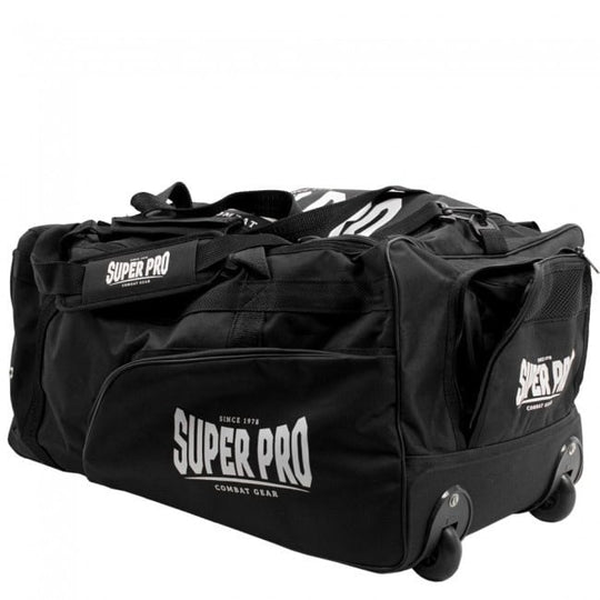 Een schuine opname van een zwarte Super Pro sporttas, waarbij de trolley functie goed zichtbaar is. Aan de onderkant zijn twee stevige wielen gemonteerd. Het grote Super Pro Combat Gear logo is duidelijk op de zijkant van de tas te zien.